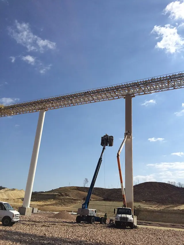 Aerial lifts raised beside freshly painted conveyor piers
